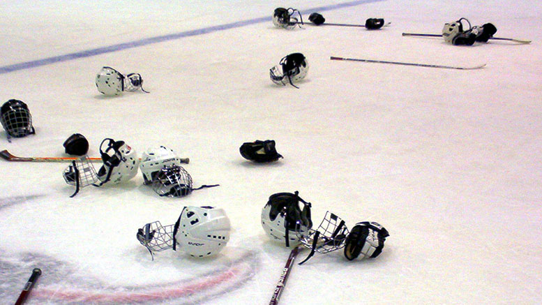Hockey helmets and sticks on rink
