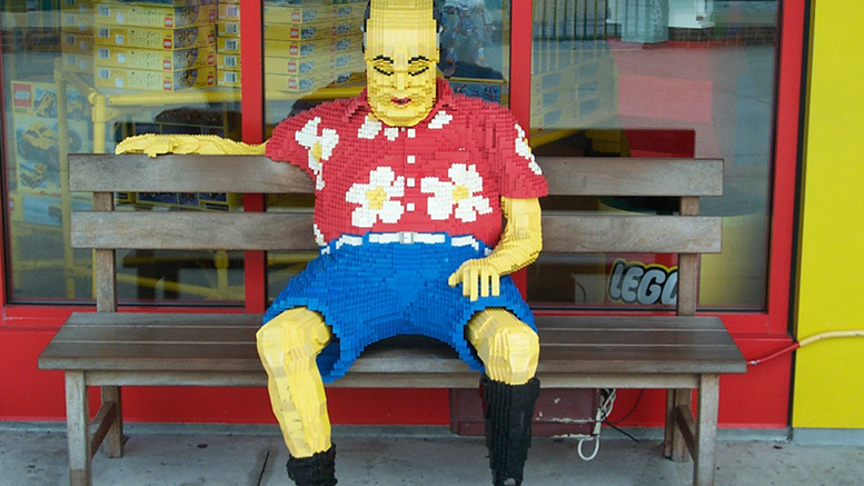 Man made out of legos, sitting on bench