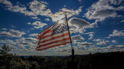 An american flag flies in the sky.