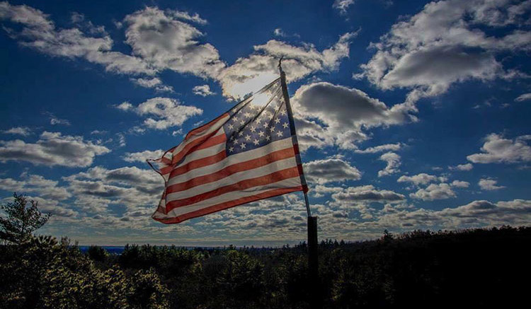 An american flag flies in the sky.