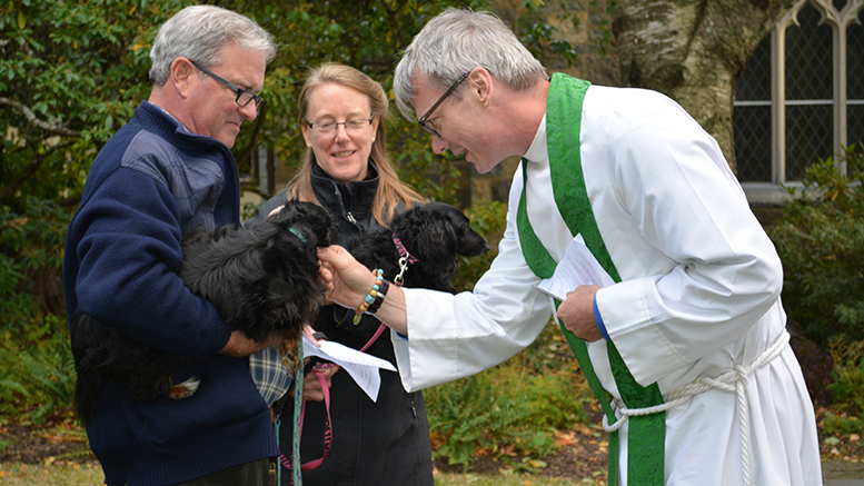 (Photo Caption: Rev. Hall Kirkham welcome pooches Fred (left) and Missy (right), along with their owners Charlie and Mary Truslow to last year's Blessing of the Animals)