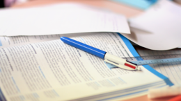 Back-to-school tips for parents: A stack of papers with a blue pen on top, supporting your child