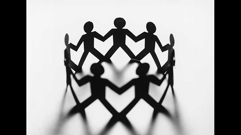 A group of people holding hands in a circle.