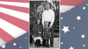 A photo of a family in front of an american flag.