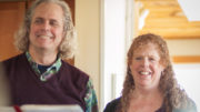 A man and woman smiling while holding a book at East Church.