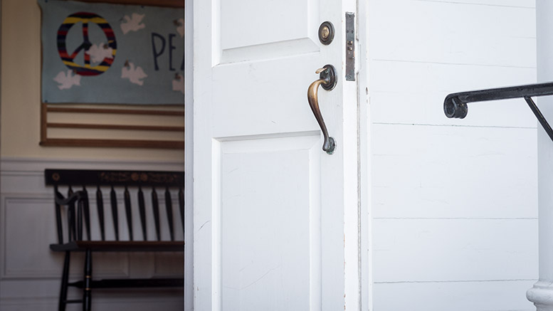 East Church to host open house on June 1st showcasing a white door with a black handle adorned with a peace sign.