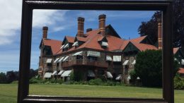 A mansion is reflected in a frame at Eustis Estate Museum.