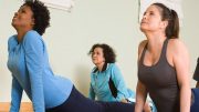 A group of women doing yoga in a gym.