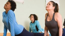 A group of women doing yoga in a gym.