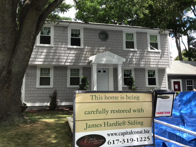 A house with a CAPITAL CONSTRUCTION sign in front of it.