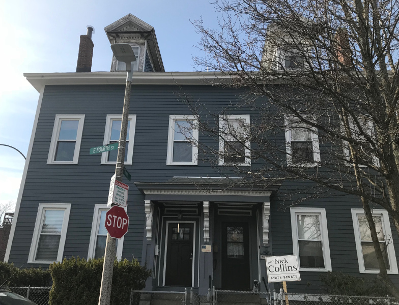 Capital Construction offers expert James Hardie siding installations for various projects, including a blue house with a stop sign in front of it.