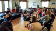 A group of people sitting in a room listening to music while Mel O'Drama launches a new program for babies and toddlers called Drama N Droolz.