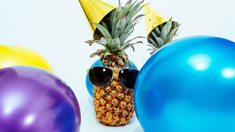 A pineapple with sunglasses on a white background.
