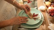 A woman from the Milton Interfaith Clergy Association is placing a place setting on a table, as they prepare for the annual Thanks for Giving Service.