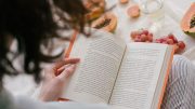 woman reading book in bed