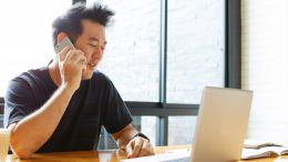 Man on computer and phone