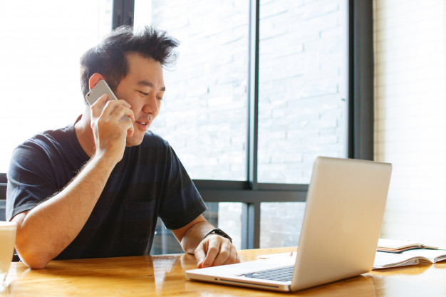 Man on computer and phone