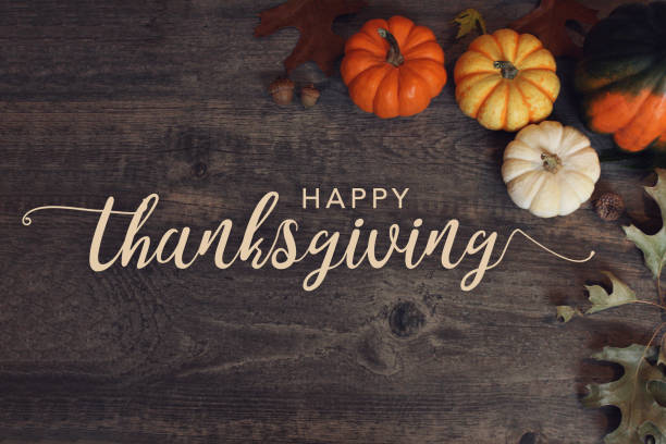 Happy Thanksgiving with pumpkins on a wooden background.