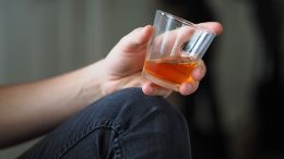 glass of alcohol in a person's hand