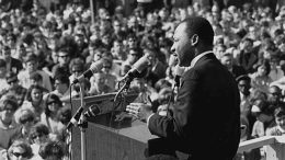 Martin Luther King Jr. giving a inspiring speech in front of a large crowd on Martin Luther King Jr. Day.