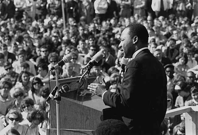 Martin Luther King Jr. giving a inspiring speech in front of a large crowd on Martin Luther King Jr. Day.