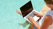 on laptop by pool