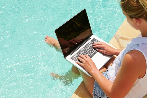 on laptop by pool