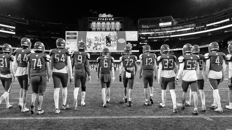 A black and white photo of football players standing on a field, showcasing the Milton Wildcats.