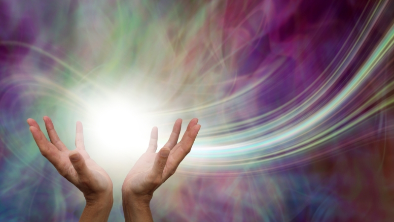 Hands with energetic light and waves. image: canva