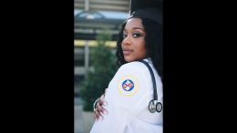 A woman on her journey to become a nurse is posing with a stethoscope.