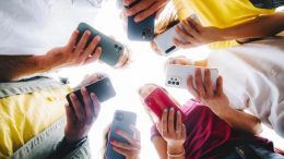 A group of teens holding cell phones / screens