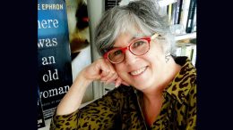 A woman with glasses reads a book at the Milton Public Library.