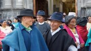 A group of men wearing hats in front of a church.