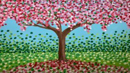 A painting of a tree with pink flowers displayed in the library.