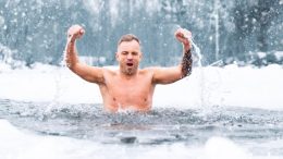 Make a Splash for a Cause: A man is swimming in the snow with his arms raised for charity at Houghton's Pond Park on March 16.
