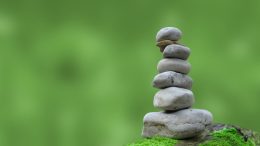A stack of stones on top of a mossy green background