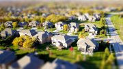 Aerial view of a suburban neighborhood with houses, greenery, and a road on the right—a perfect illustration for diversifying an investment portfolio.