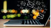 Illustrated email icons hover above a laptop keyboard, set against a vibrant backdrop of colorful lights. Discover how the Pomodoro technique can help your small business stay focused and energized in this captivating scene from Small Business Corner.