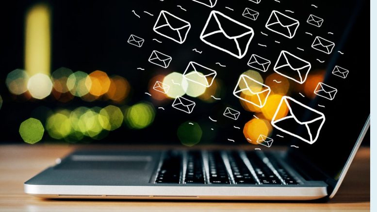 Illustrated email icons hover above a laptop keyboard, set against a vibrant backdrop of colorful lights. Discover how the Pomodoro technique can help your small business stay focused and energized in this captivating scene from Small Business Corner.