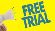 A hand holds a megaphone against a yellow background, proclaiming "FREE TRIAL" in bold blue letters—just one of the simple strategies for successful email marketing, as advised by the Small Business Corner.