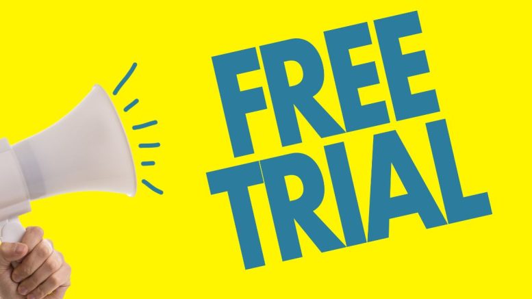 A hand holds a megaphone against a yellow background, proclaiming "FREE TRIAL" in bold blue letters—just one of the simple strategies for successful email marketing, as advised by the Small Business Corner.