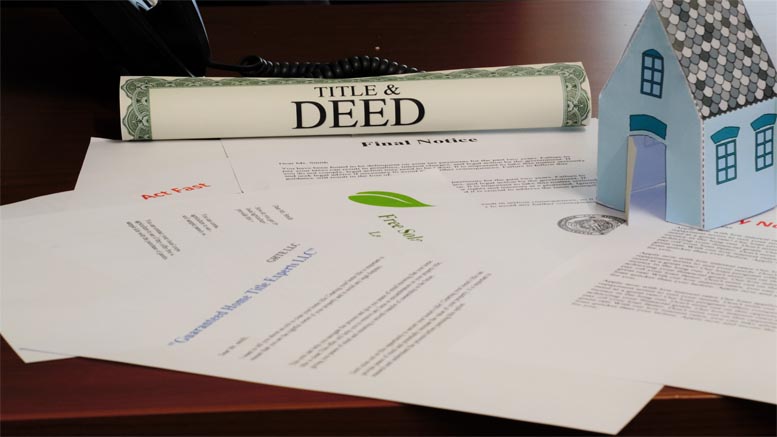 A rolled-up title and deed document, final notice letter, assorted papers, and a small model house are placed on a desk—reminding homeowners about the risk of deed fraud and the benefits of a free alert service.