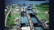 Aerial view of Panama Canal locks with multiple chambers, surrounded by green areas, buildings, and a waterway—perfect for travel talk sessions or educational events at Milton Library.
