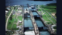 Aerial view of Panama Canal locks with multiple chambers, surrounded by green areas, buildings, and a waterway—perfect for travel talk sessions or educational events at Milton Library.