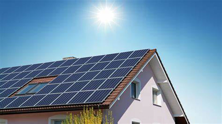 A house with a slanted roof covered in solar panels is shown under a clear blue sky, highlighting homeowners who benefit from a solar panel contract registered in Norfolk County.